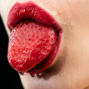 Leinwandbild Eine Frau Mit Einer Erdbeere Im Mund